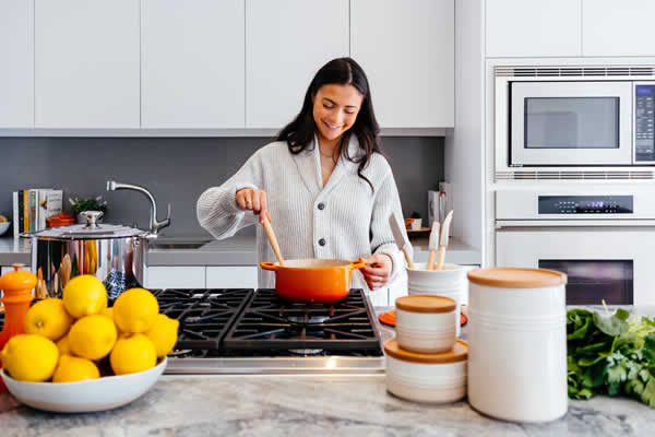 lady cooking stiring pot in kitchen