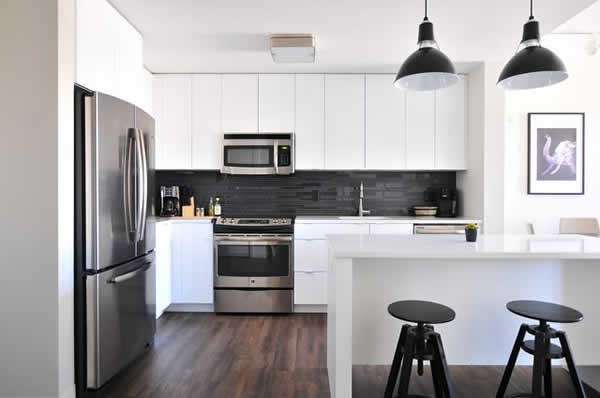 kitchen showing major appliances, counter space and bar stools